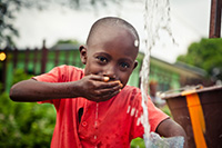 boy drinking water from his hand